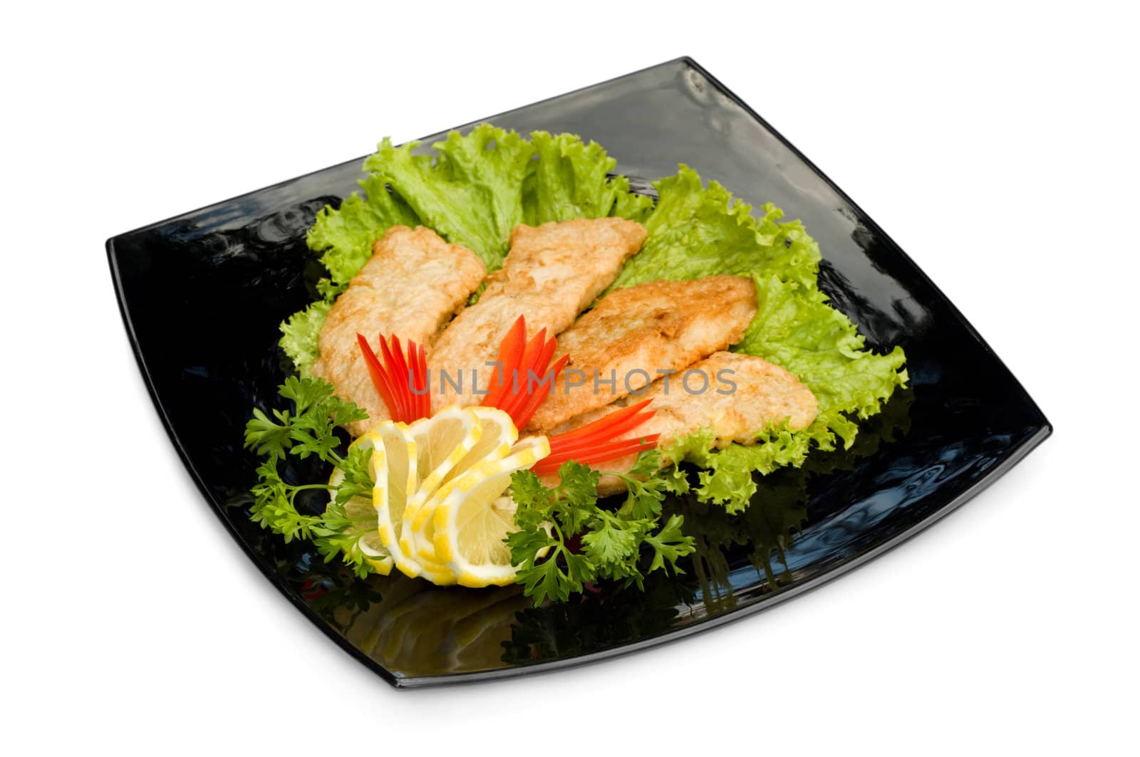 fried chicken fillet with fresh vegetables, on black square plate, isolated