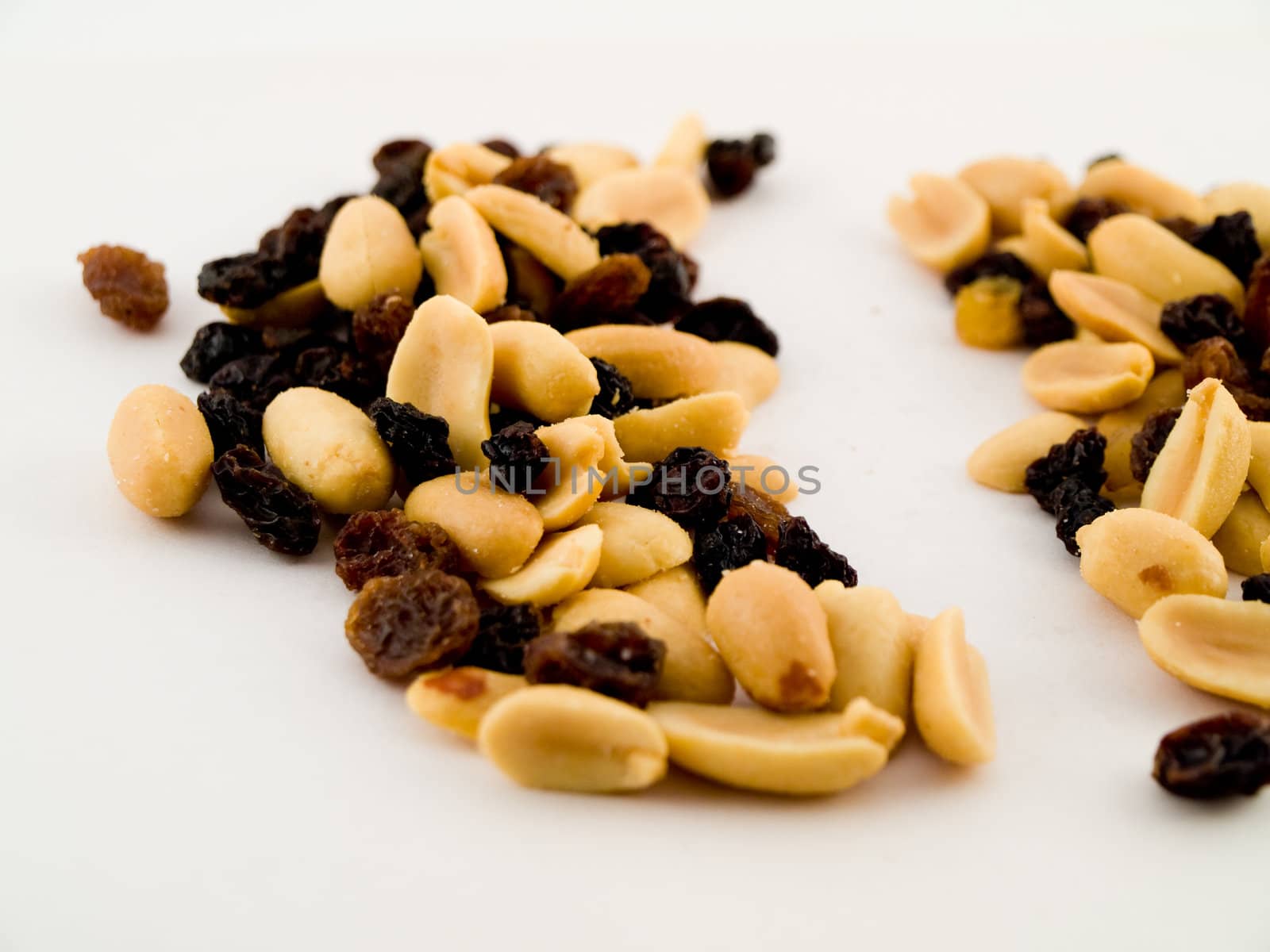 Stack Pile of Peanuts and Raisins on White Background by bobbigmac