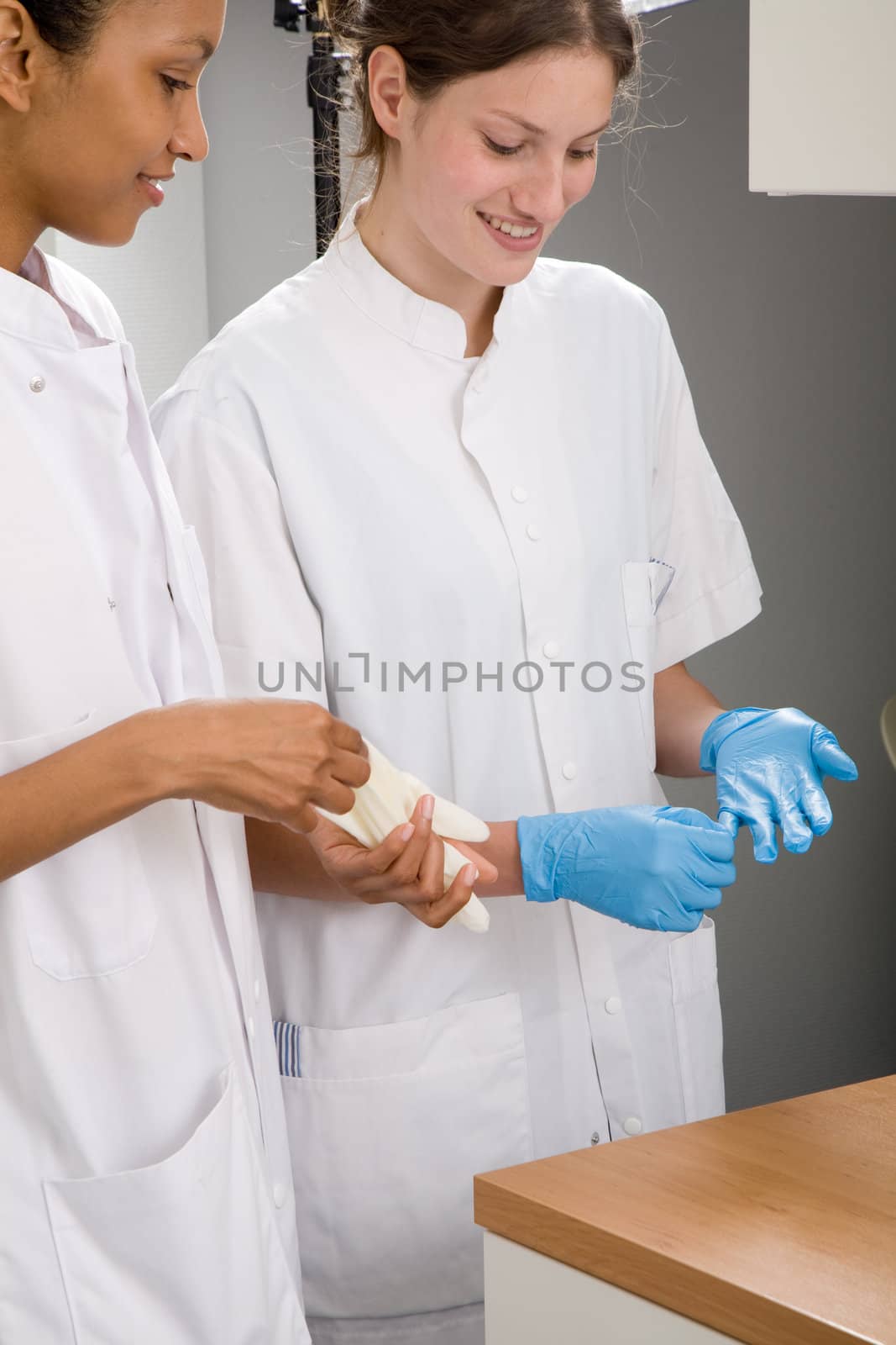 Two young medical students with latex gloves