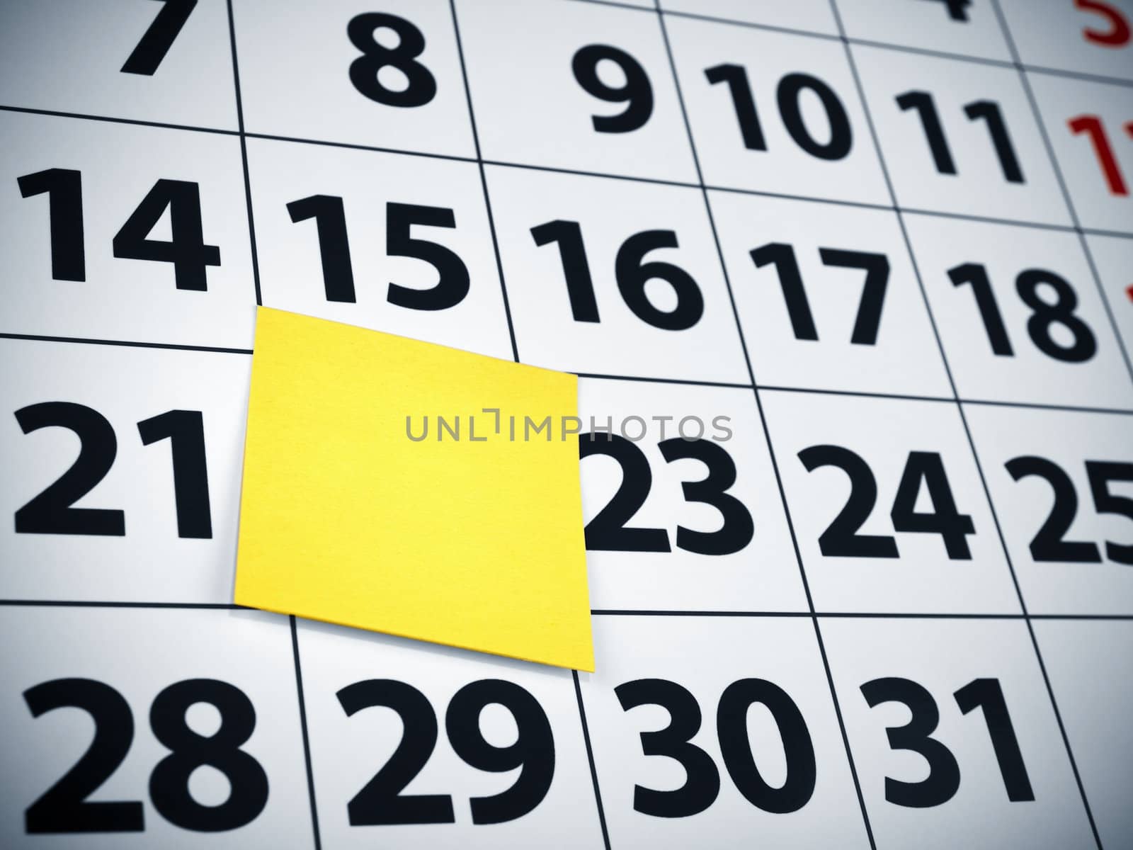 Close up of a blank sticky note on a calendar.