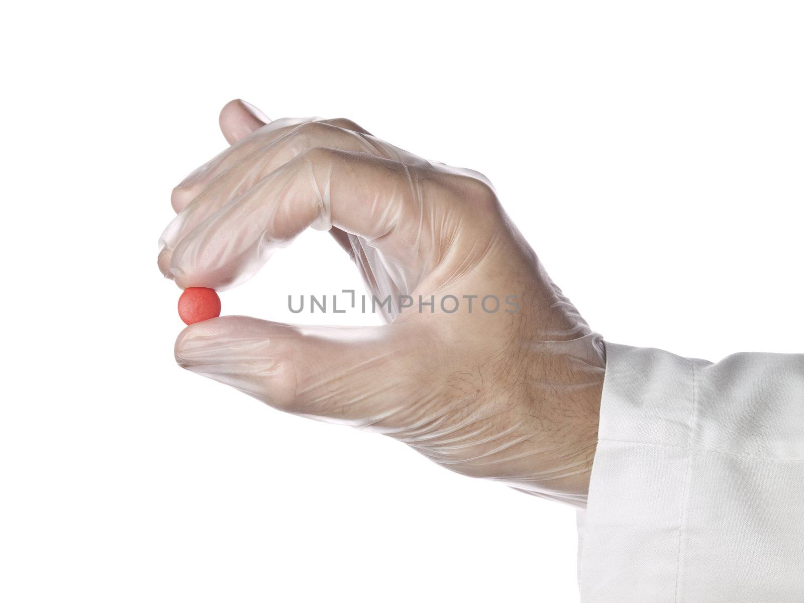 A doctor holds a red pill with his latex gloves on. Isolated on white.