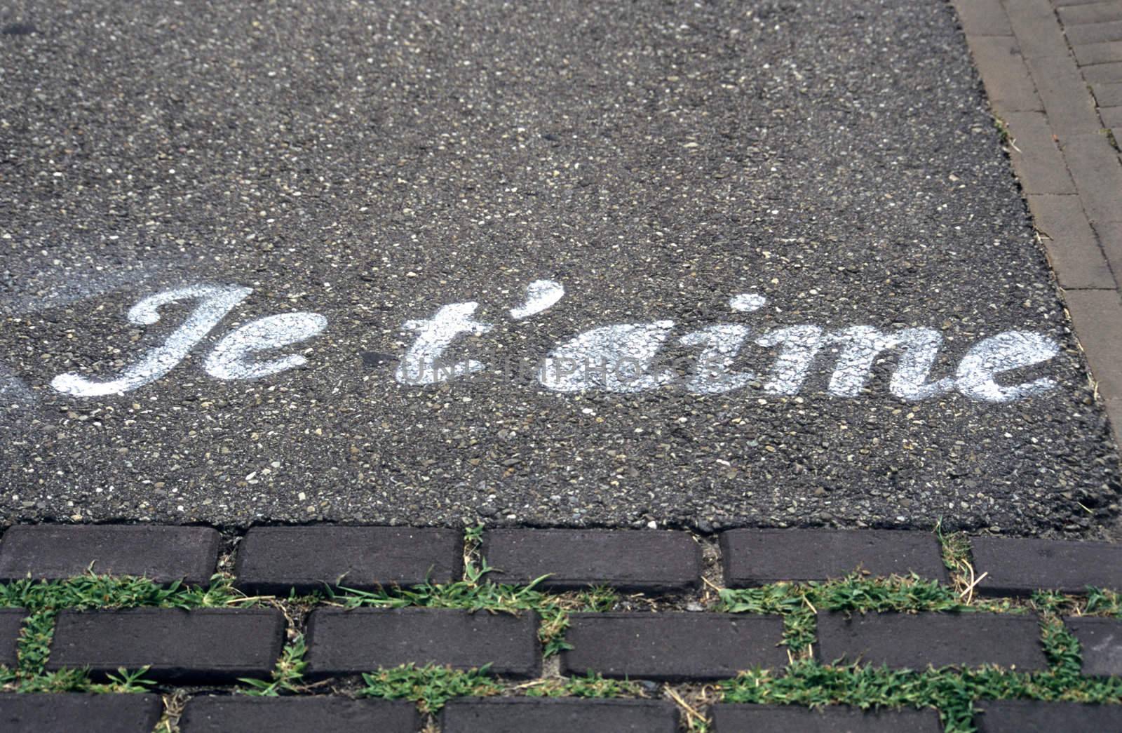 Romantic (but illegal) street grafitti in Amsterdam says I love you in French.