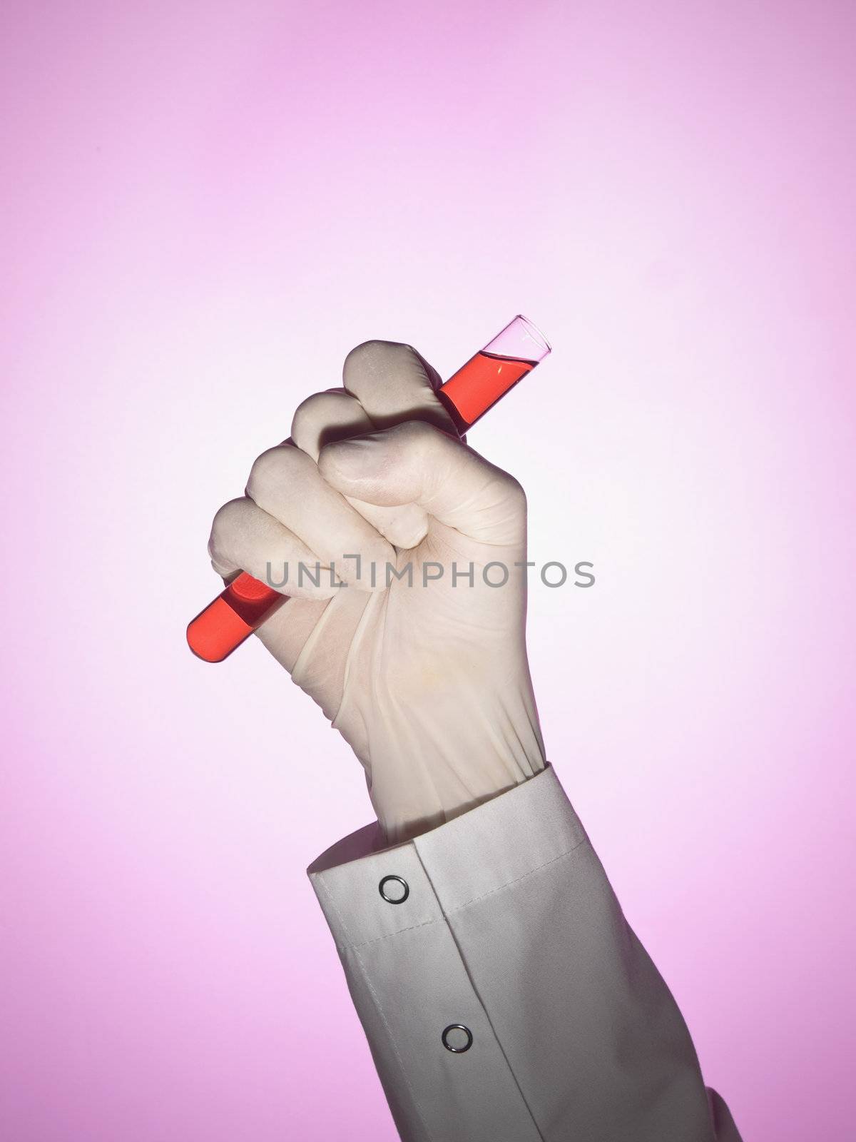 A scientist holds a test tube on his fist.