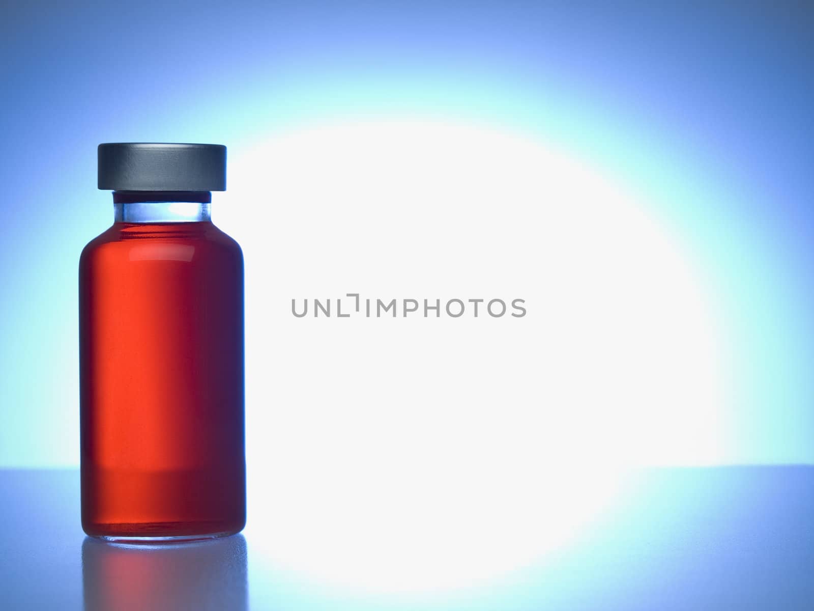 Close up of a vial filled with red liquid. Copy space.