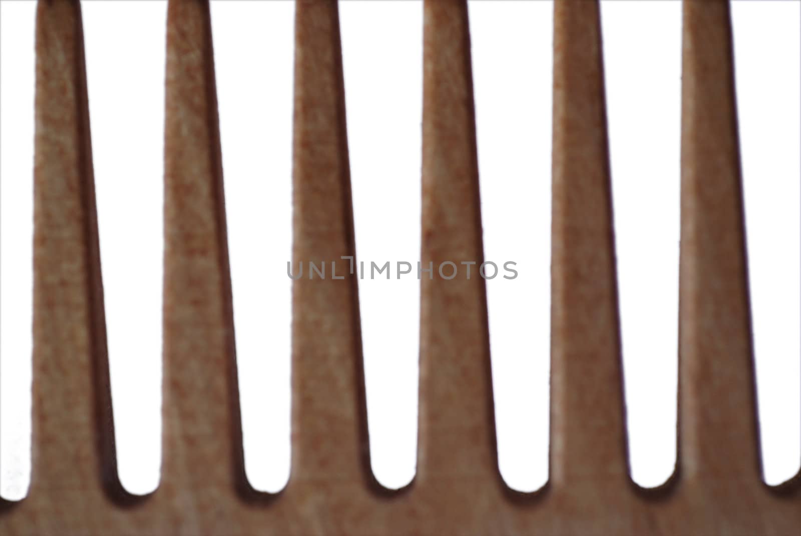 An extreme close up photograph of the teeth of a wooden comb