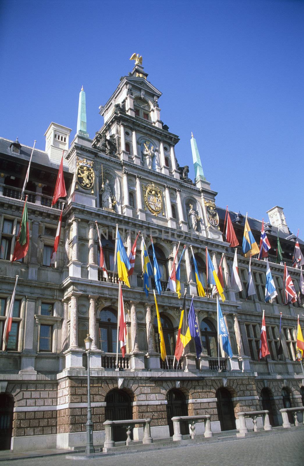 The city hall of Antwerp, Belgium is covered with flags.