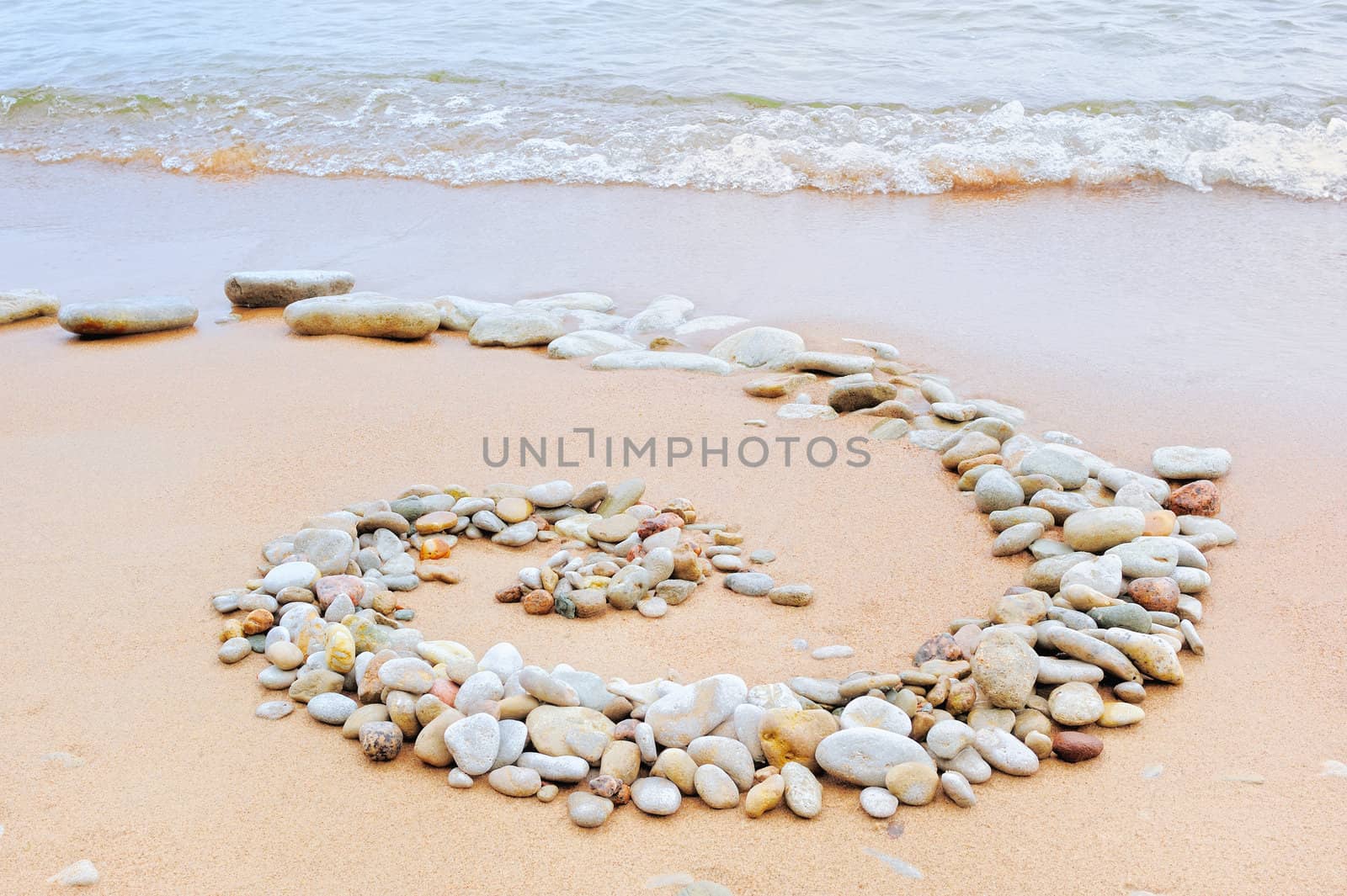 Spiral of gravel on the sandy shore