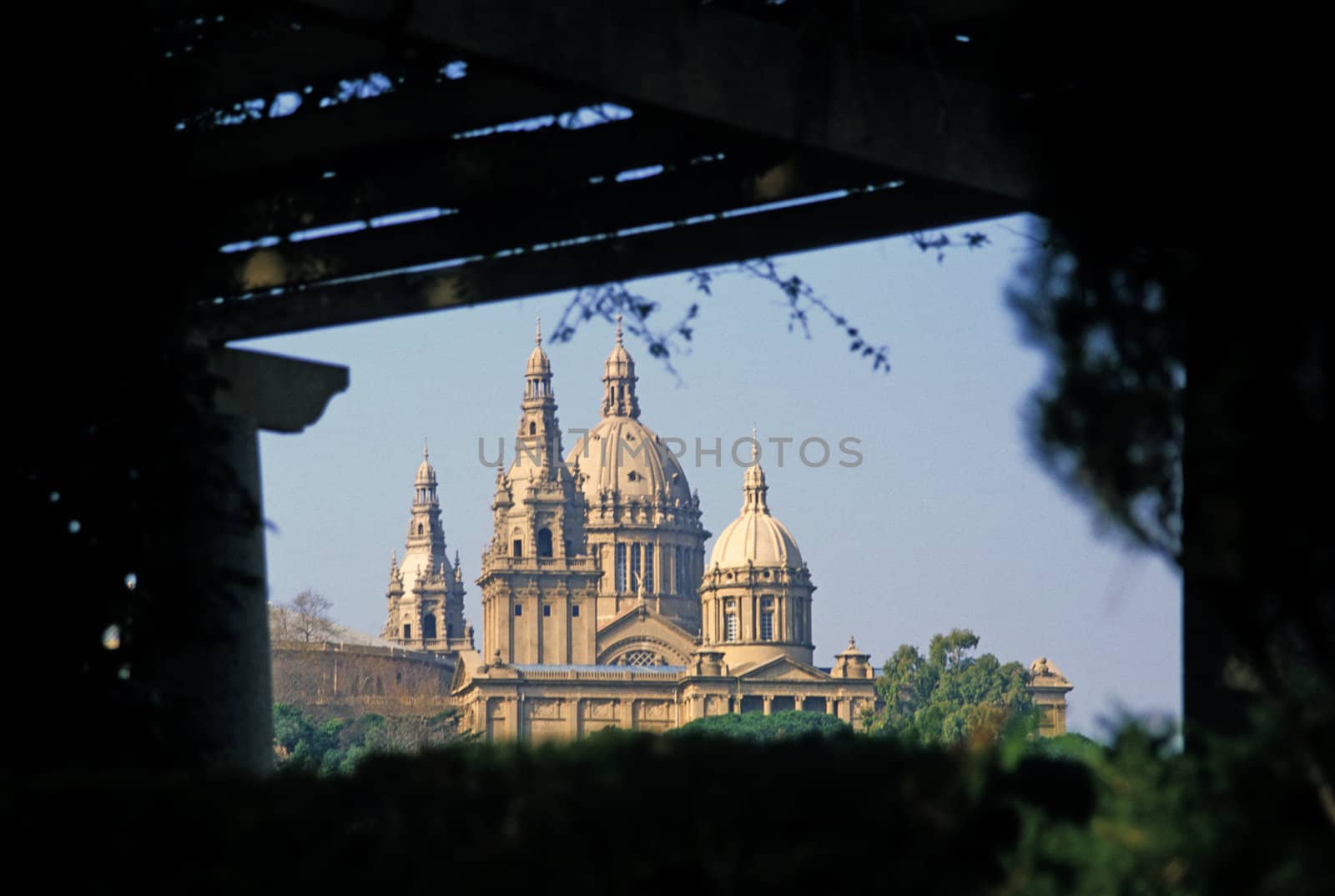 The royal palace in Barcelona through a trellis in Montjuic park.