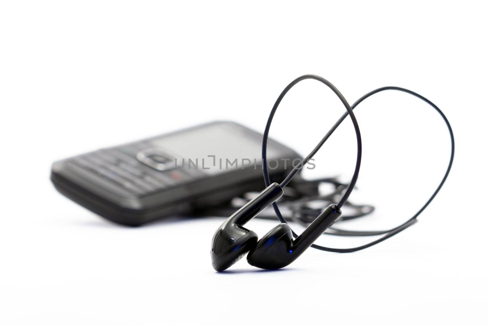 Small headphones on white background with modern mobile phone