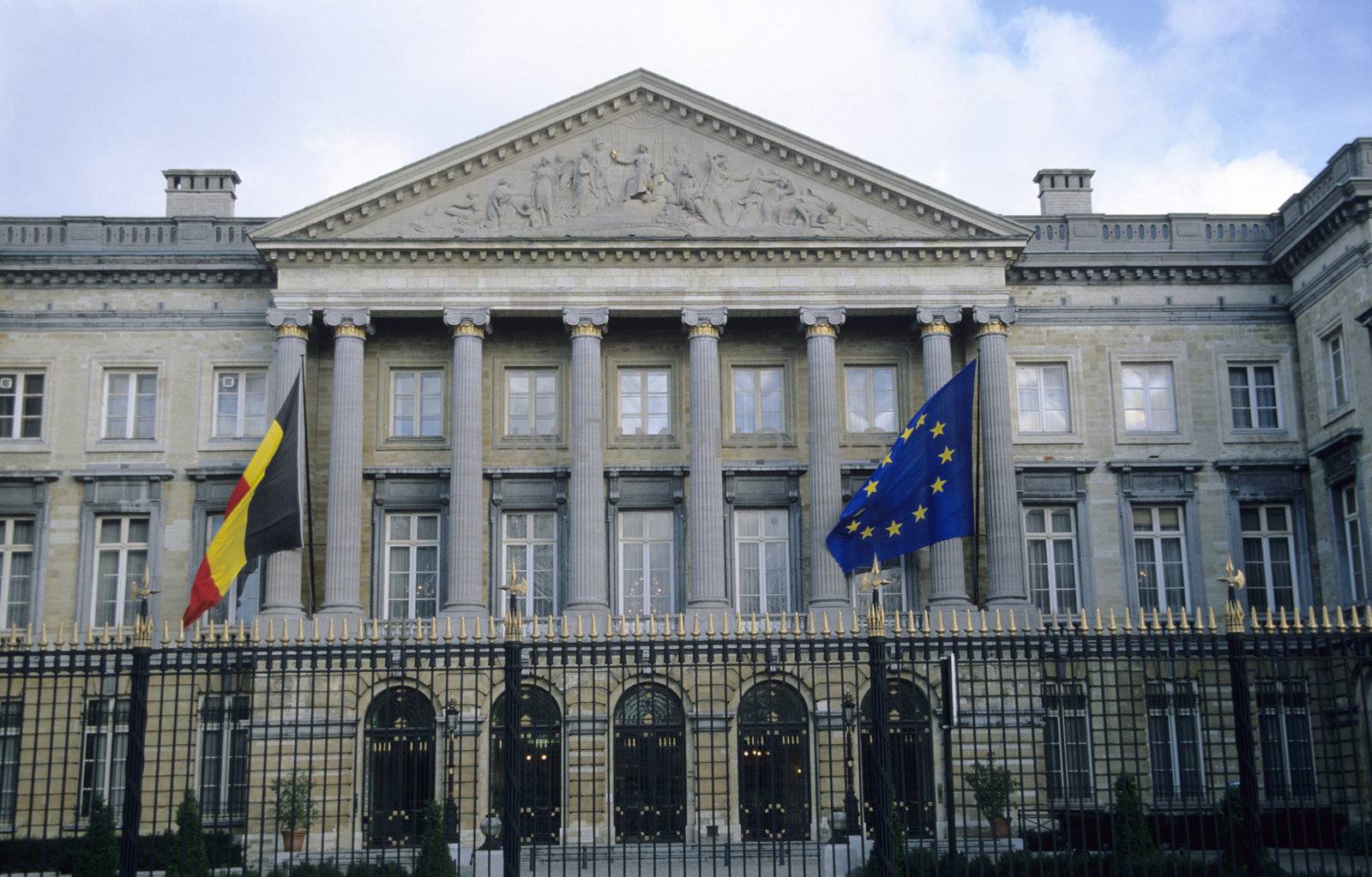 The Belgian Parliament Building with Belgian and European Union flags.