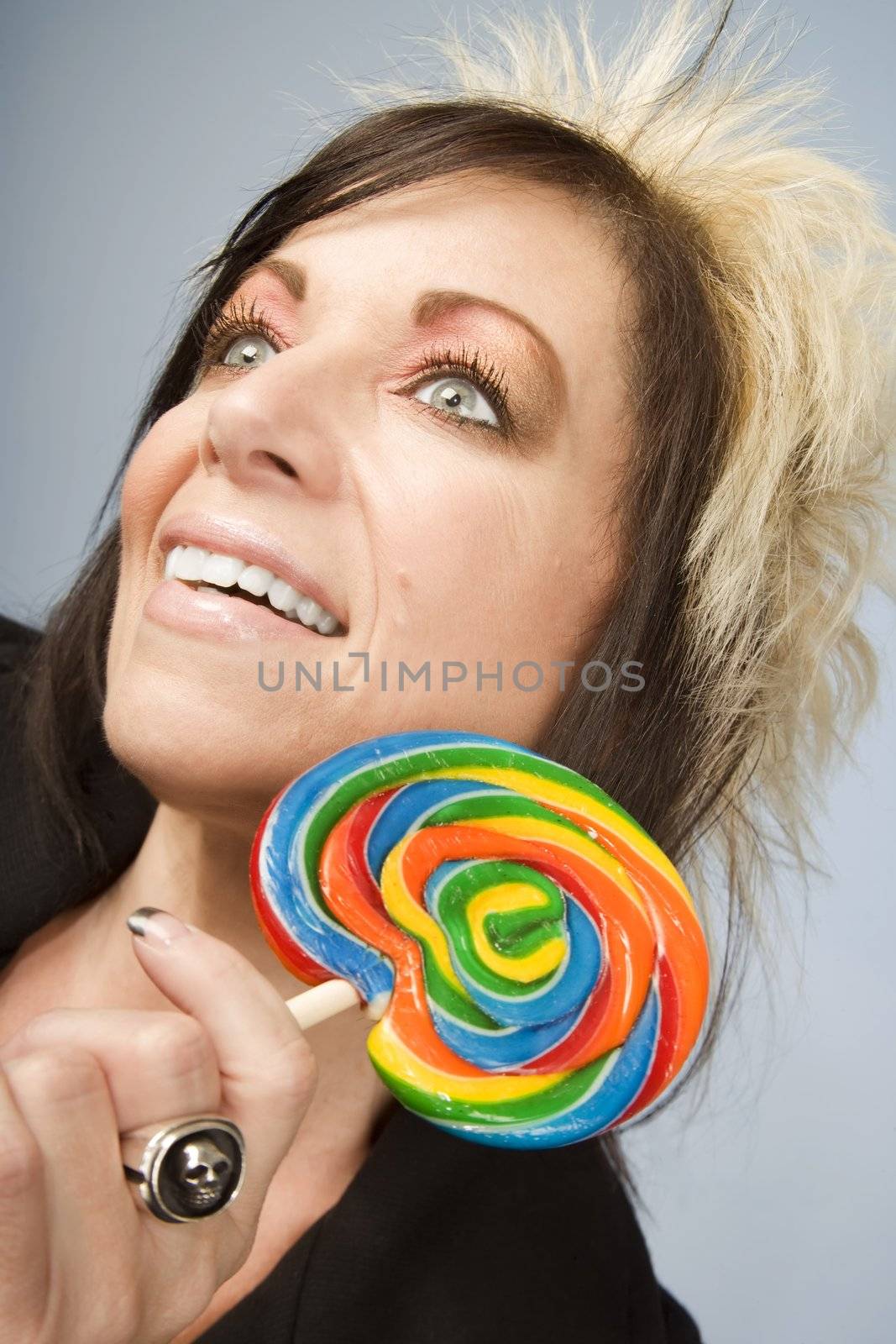 Portrait of a creative businesswoman with wild hair holding a lollipop