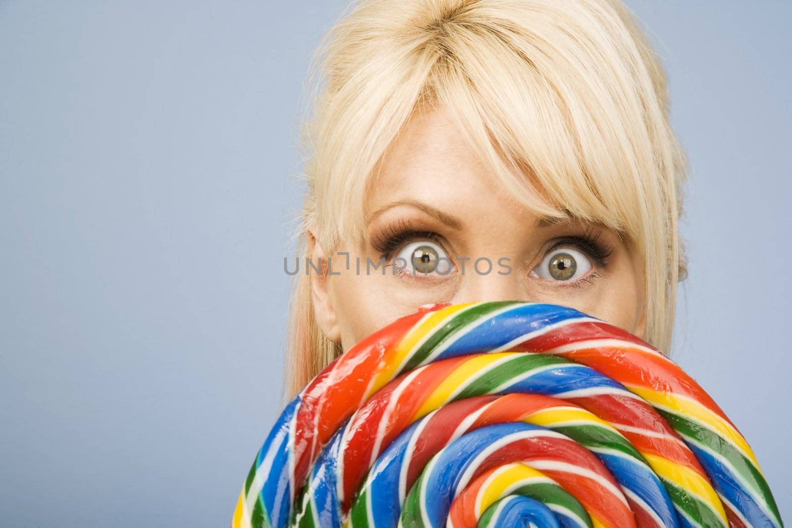Woman holding a big colorful lollipop