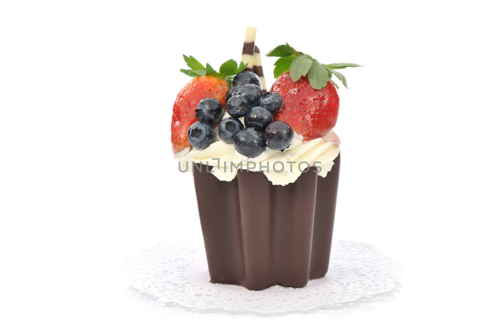Chocolate cake with cream, blueberries and strawberries on white background