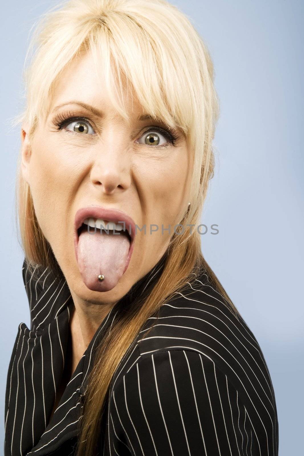Woman sticking out her pierced tongue by Creatista