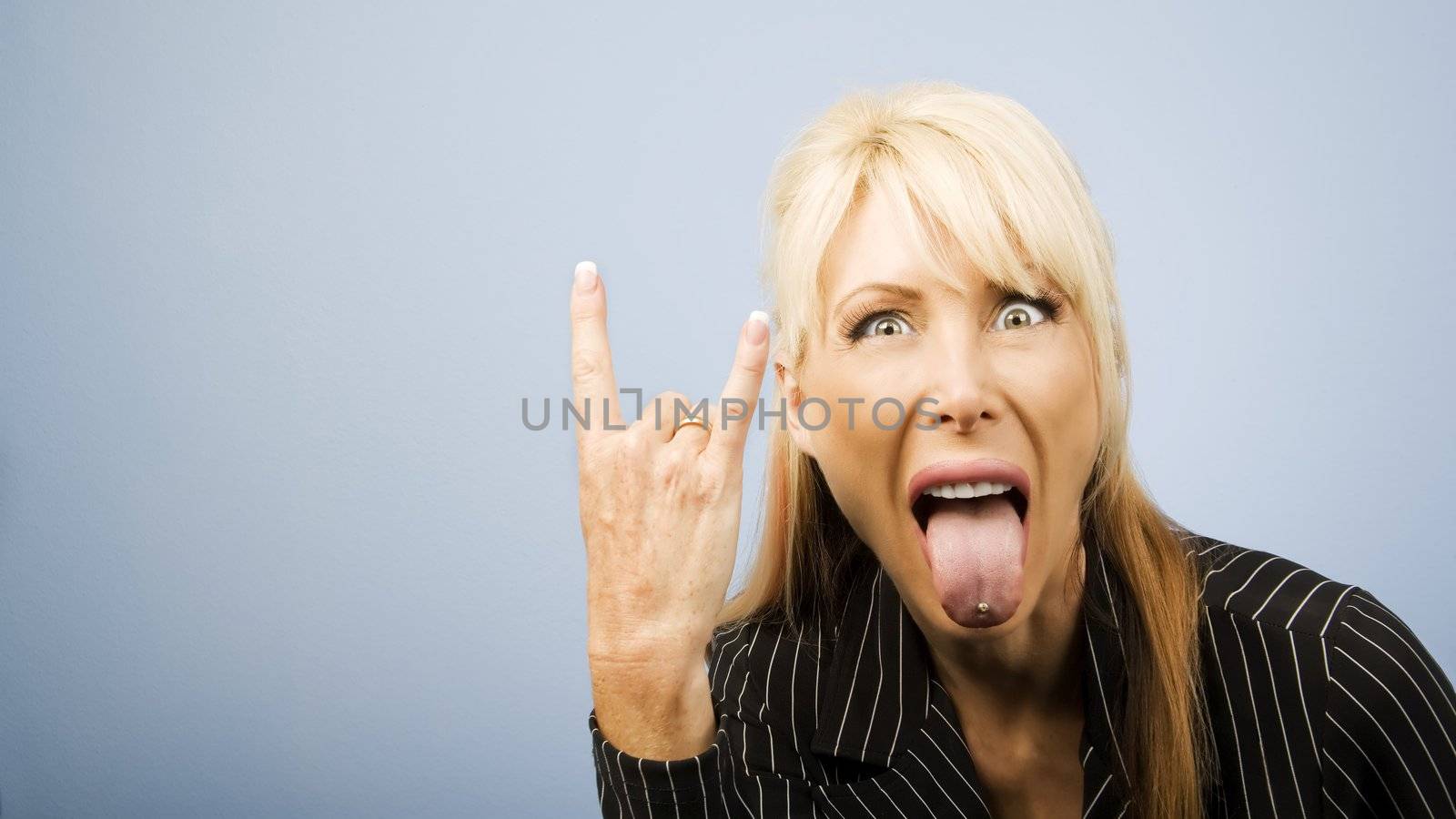 Businesswoman in a pinstripe suit making a bull horns sign