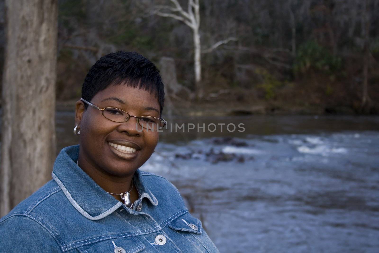 African American woman standing in front of a river