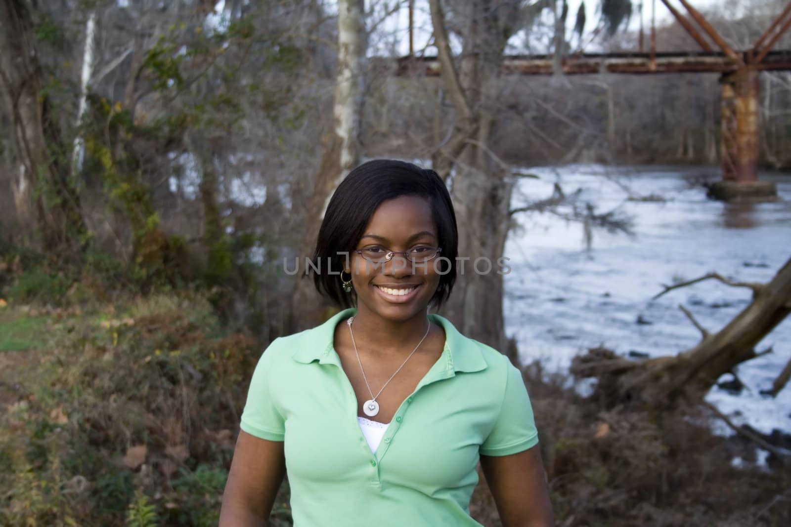 an african-american girl standing in front of a river