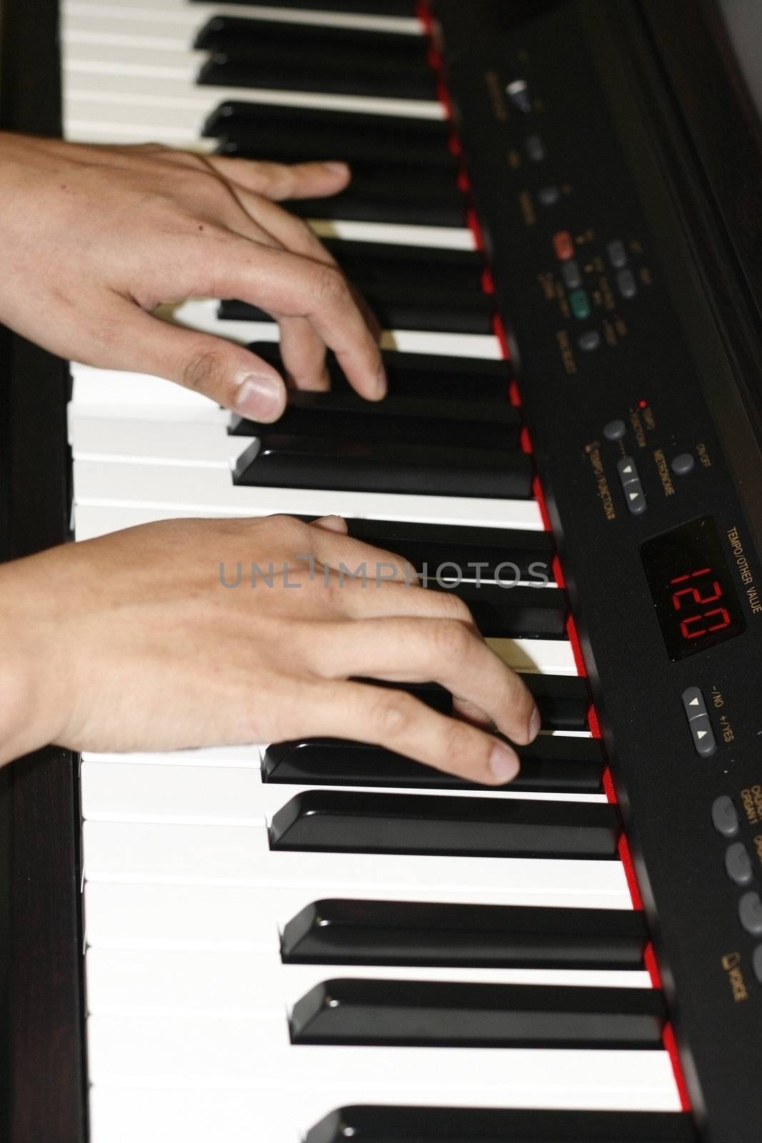 close up of a man's hands playing a piano keyboard