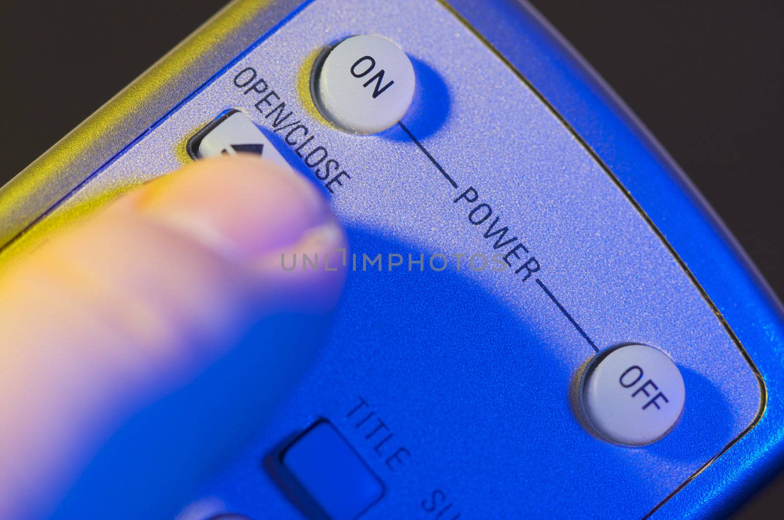 Abstract Remote with Finger Heading for the On button.