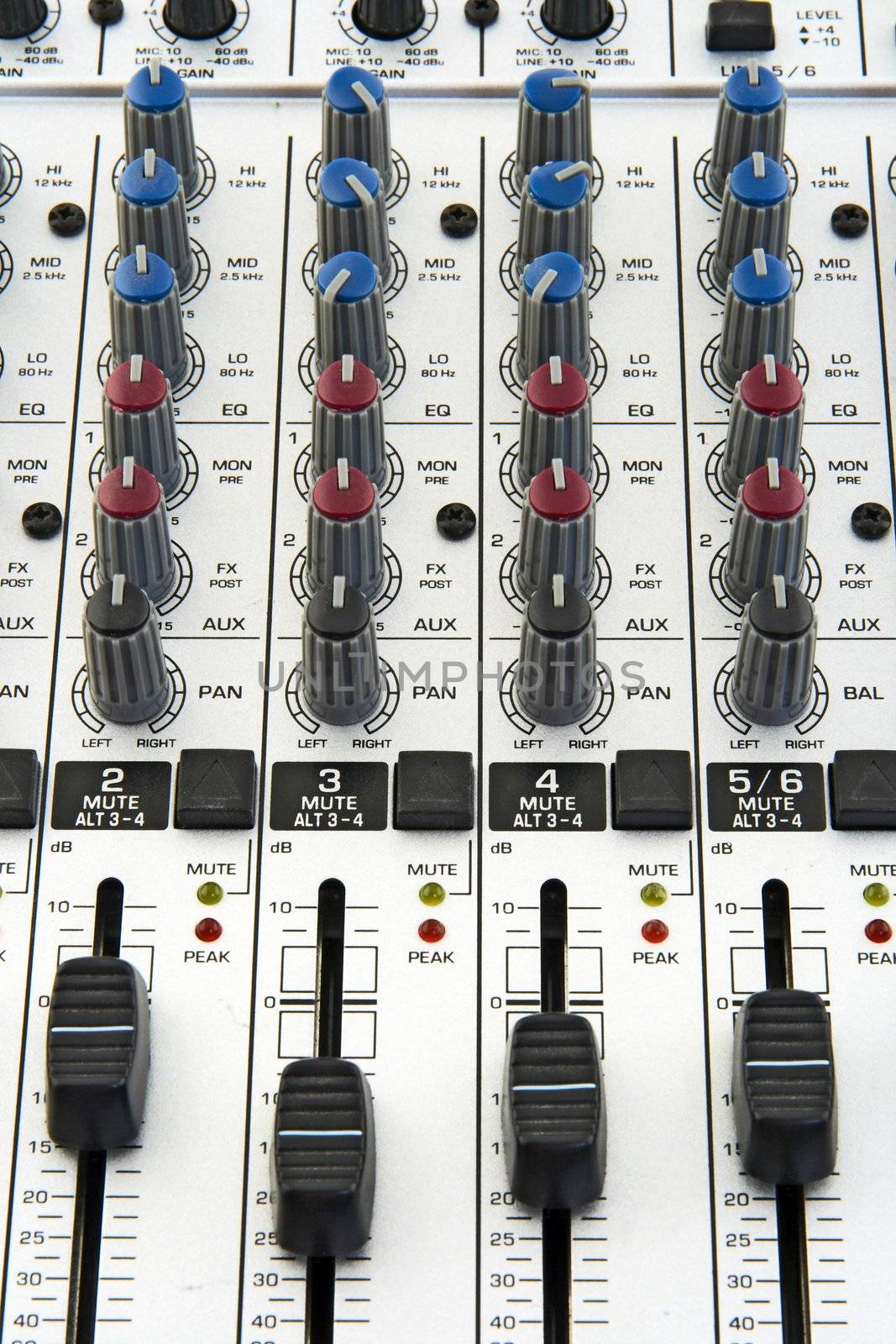 Faders and knobs of a sound mixer for audio recording.