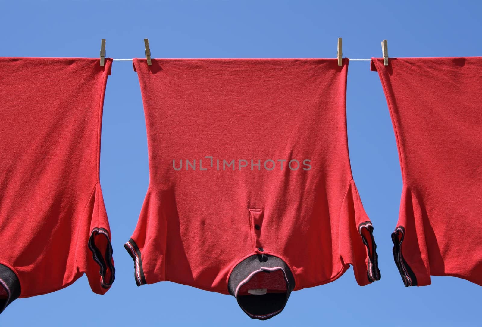 Laundry closeup, three red t-shirts on a clothes-line.