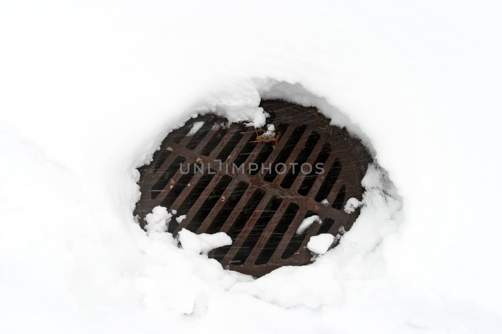 Snow melted around the drain manhole cover.