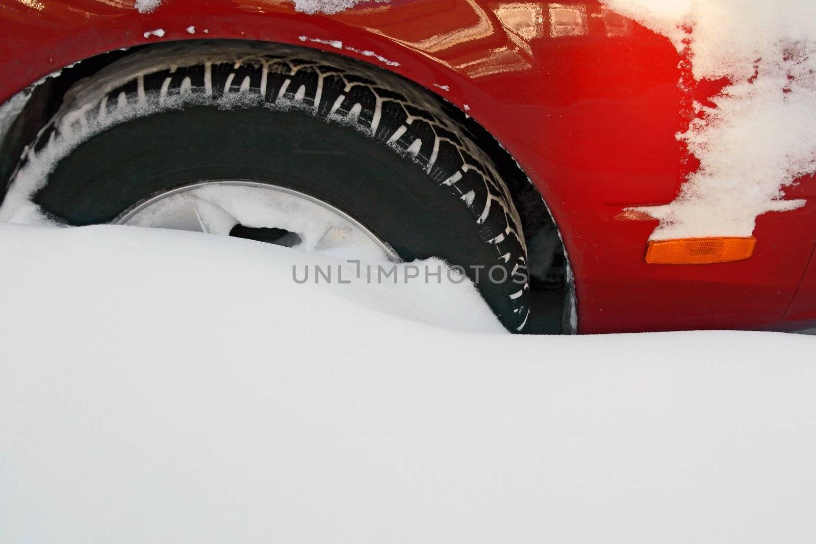Car wheel stuck in the deep snow after the heavy snowstorm.