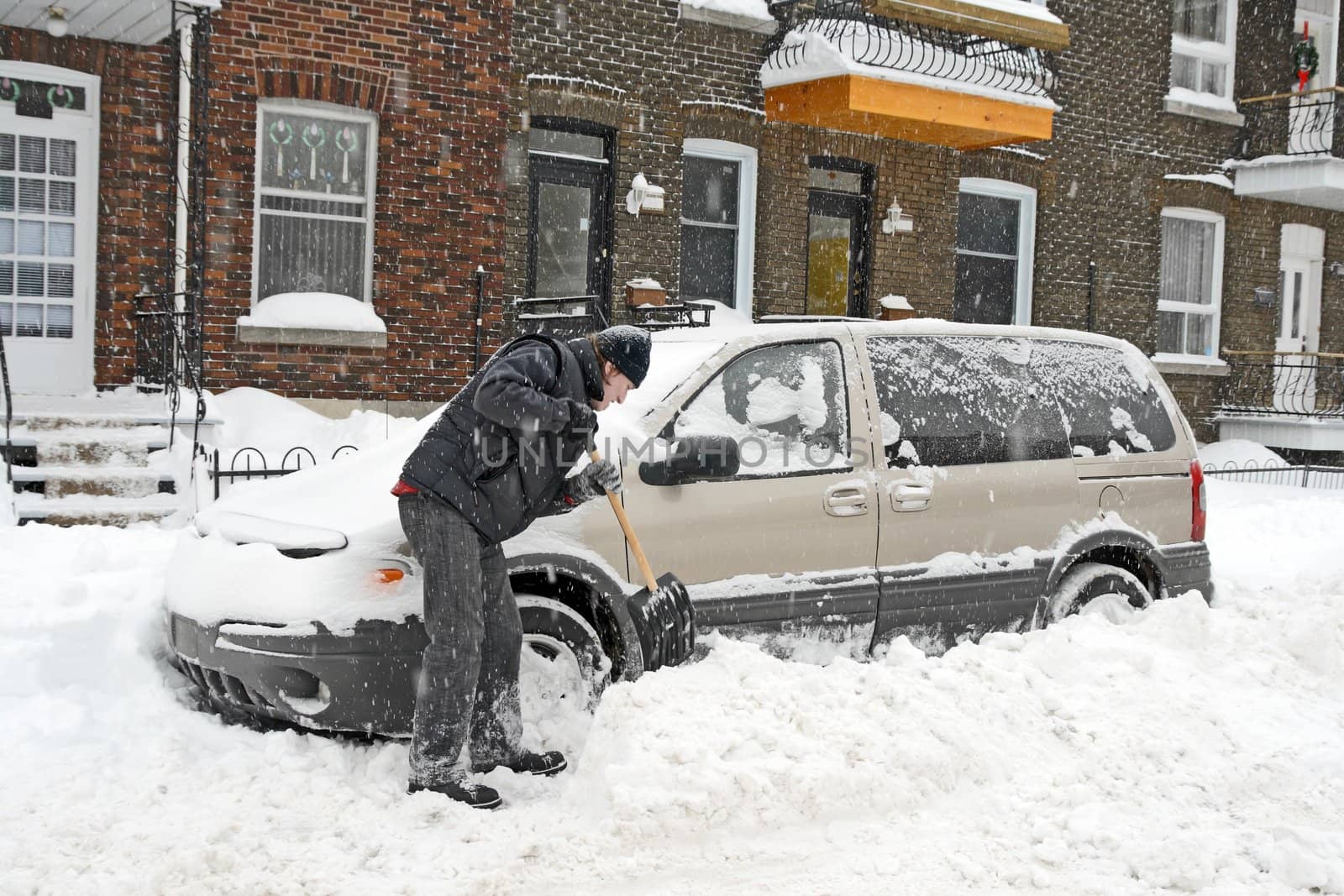 Man shovelling and removing snow by anikasalsera