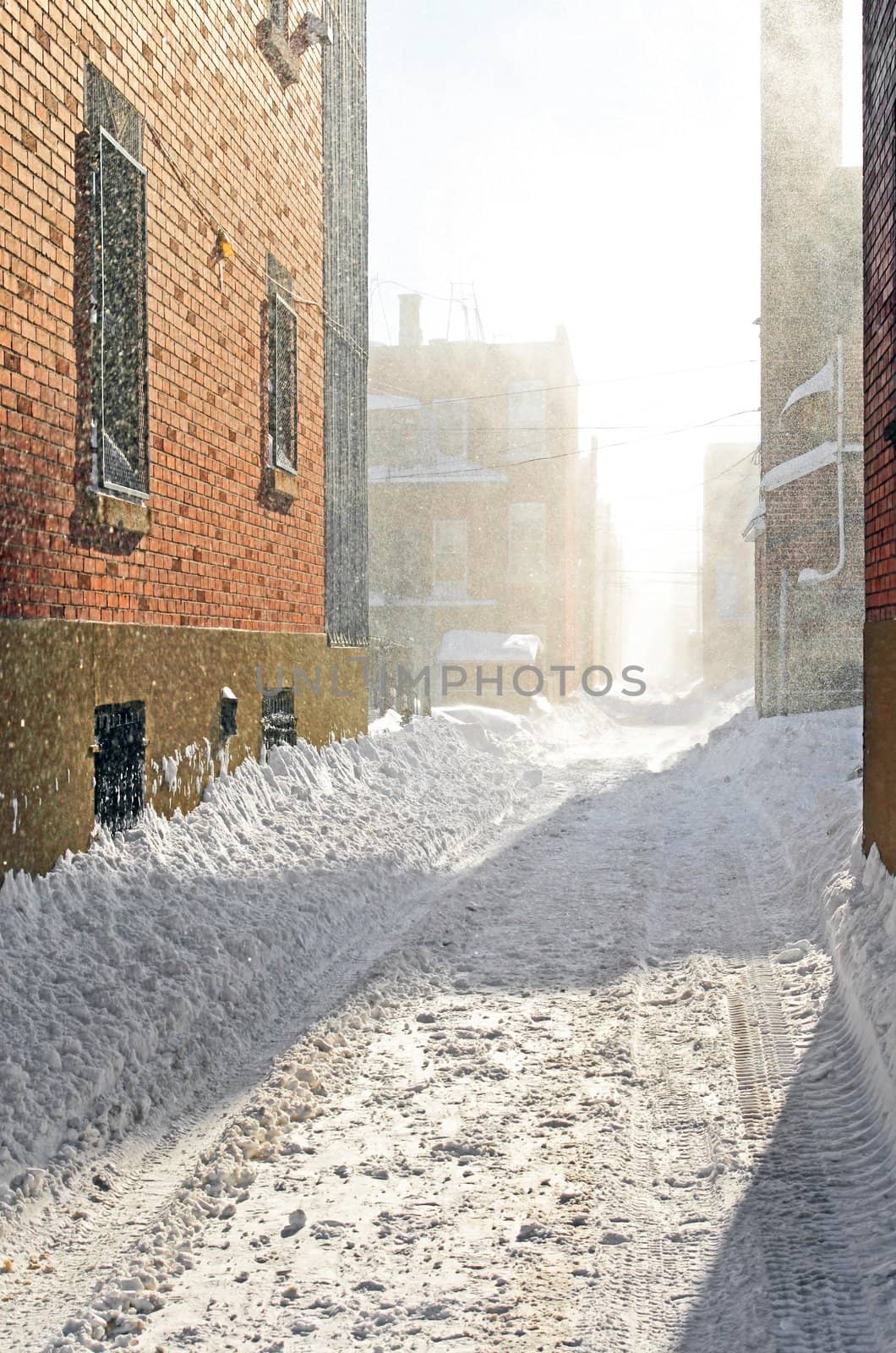 Snowstorm in the sunlight. Urban street covered by snow.