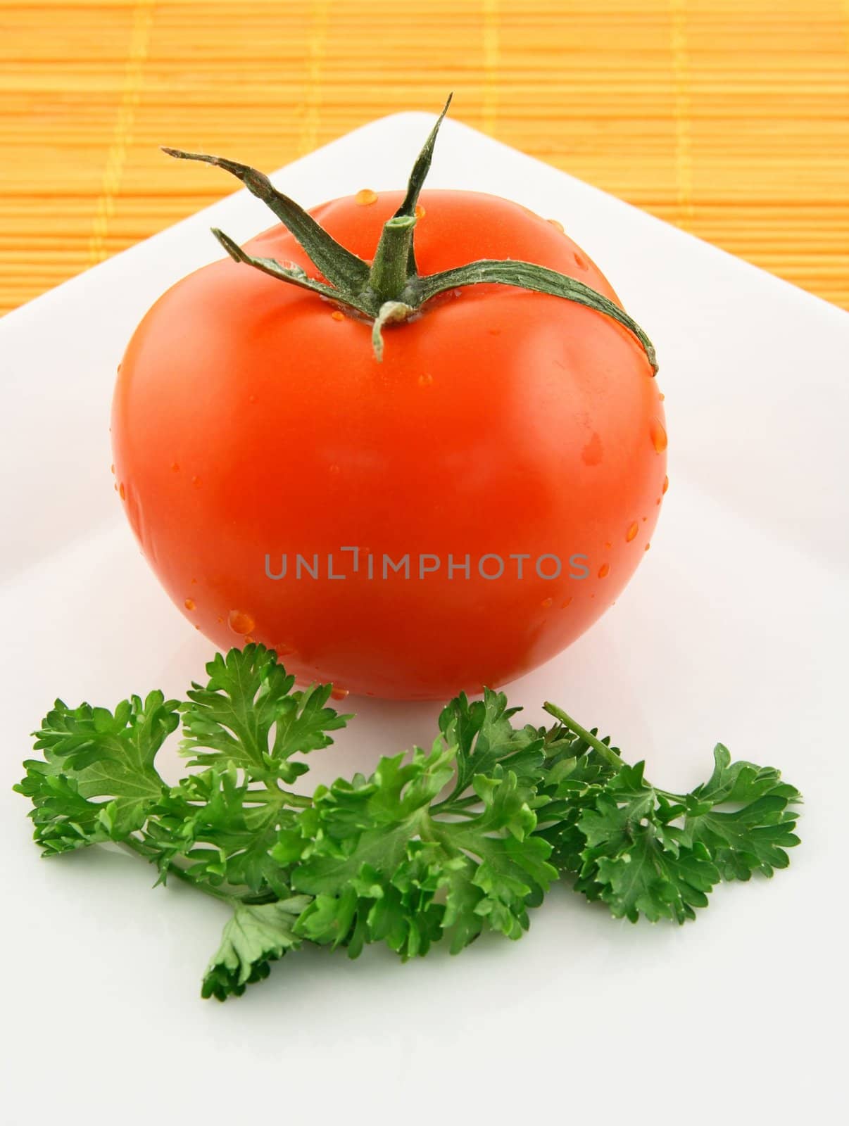 Fresh tomato and parsley on a plate by anikasalsera