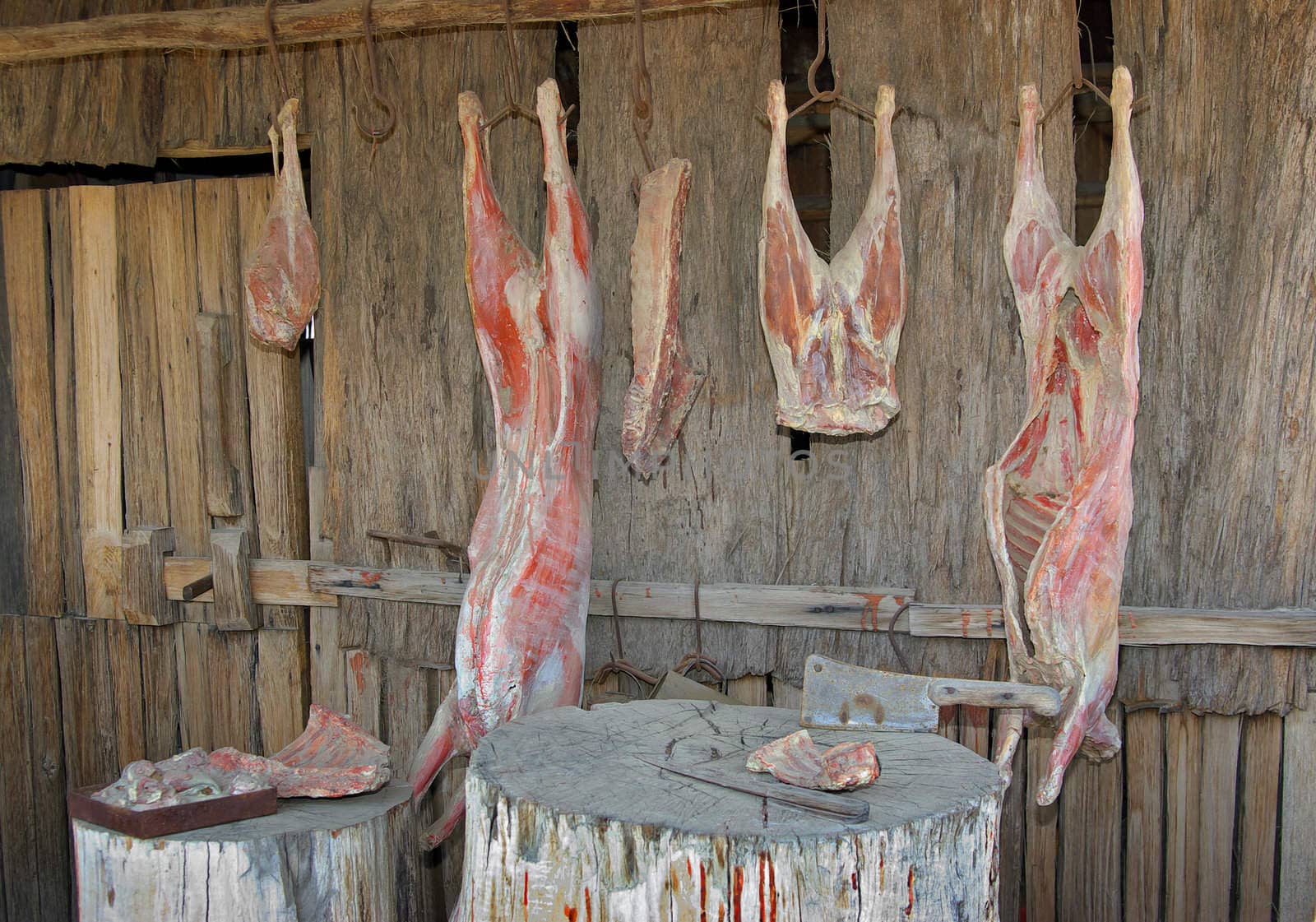 meat hangs in the heat in front of old heritage butchers shop