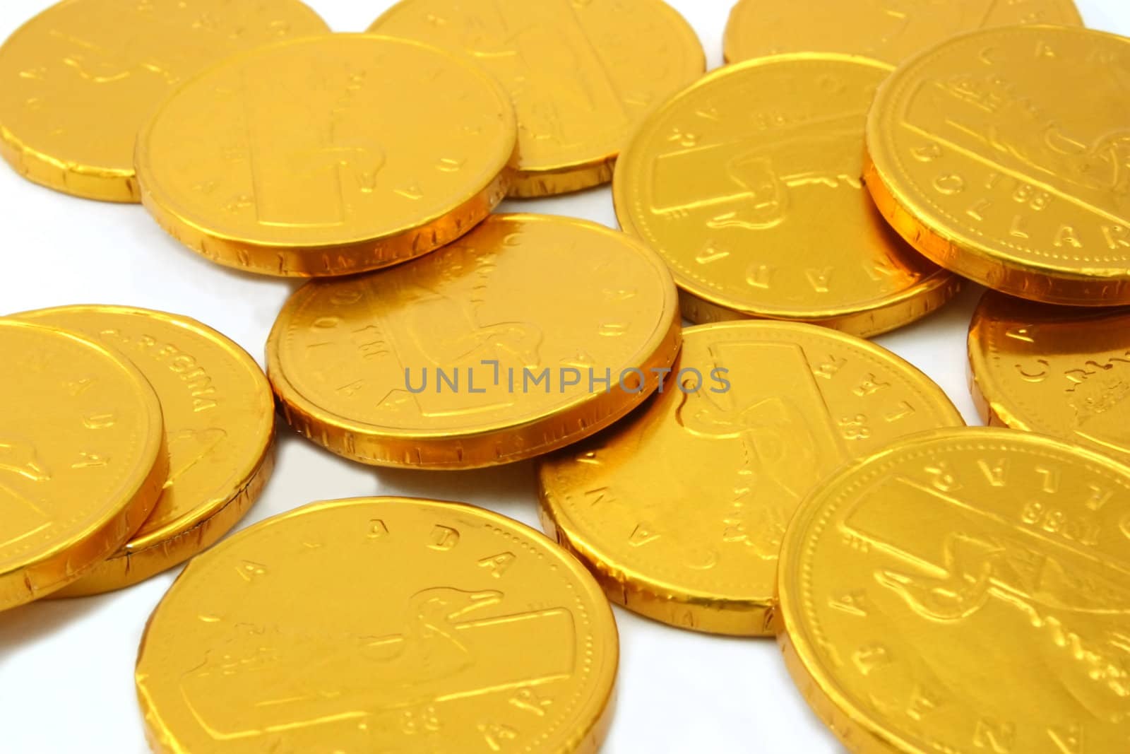 Scattered gold chocolate coins, white background