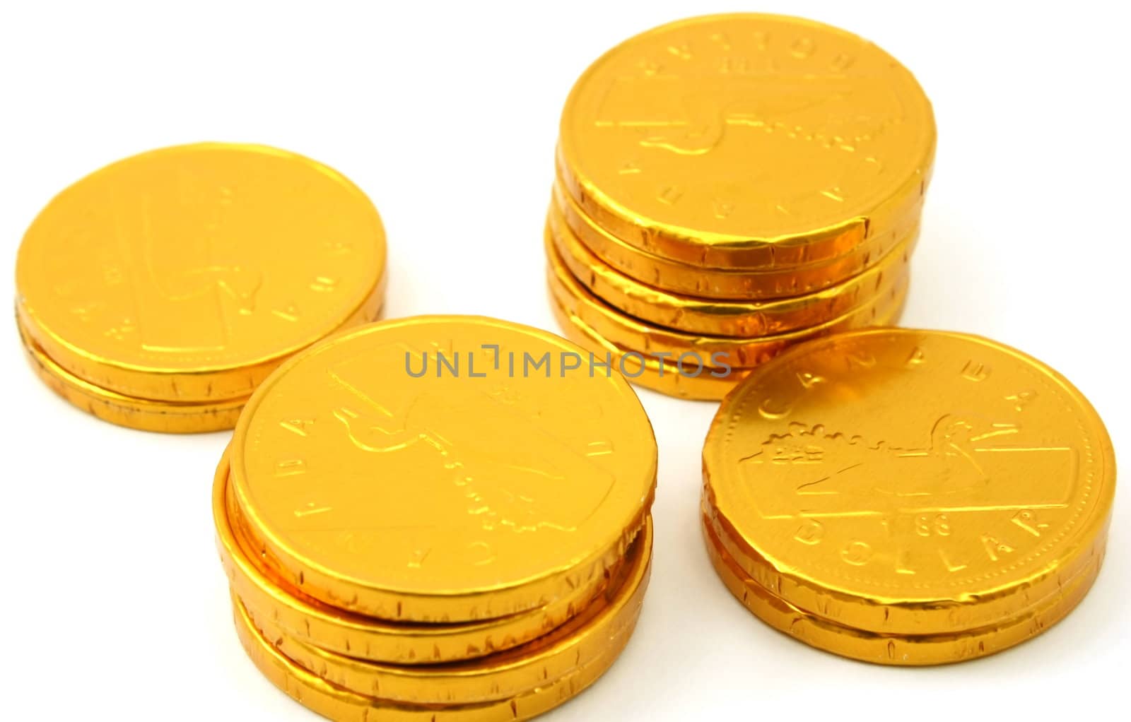 Four stacks of chocolate gold coins, isolated