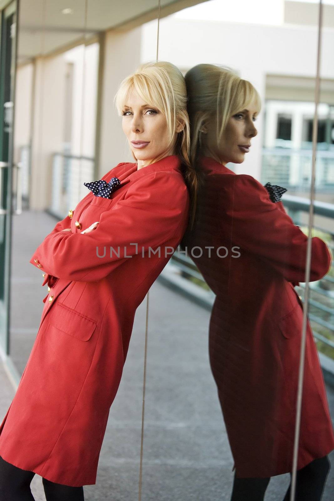 Blonde Businesswoman leaning against a reflective surface