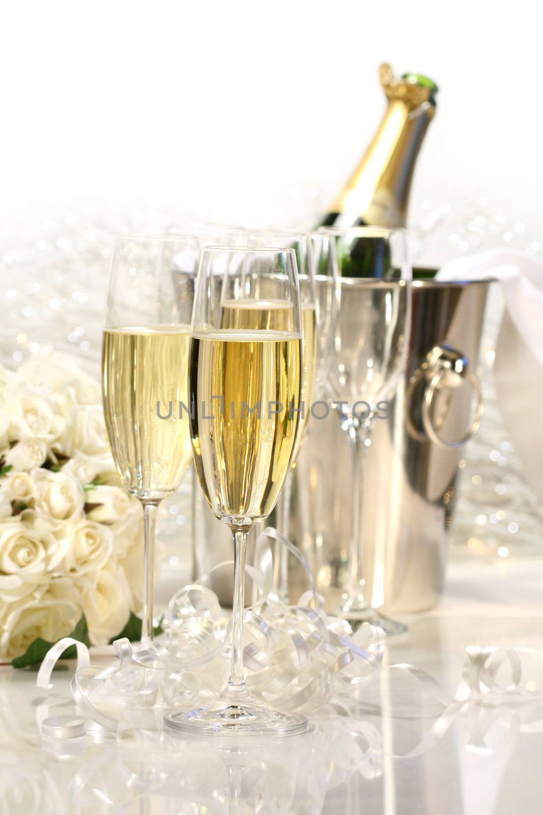 Glasses of champagne, roses, and a bottle of champagne