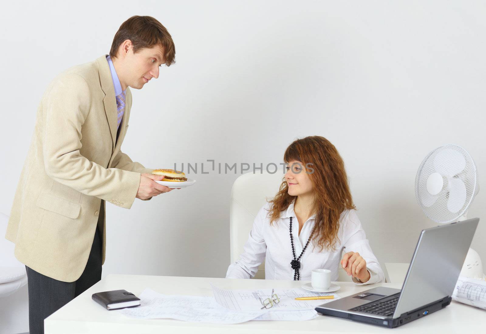 Businessman treats hamburger colleague in the office