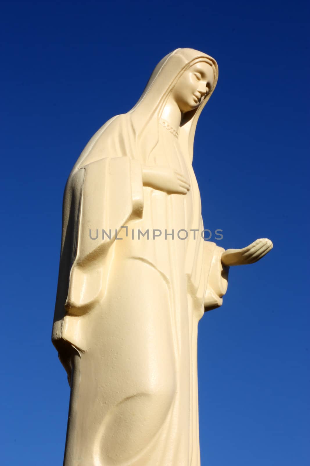 Statue of the Blessed Virgin Mary in front of the sky