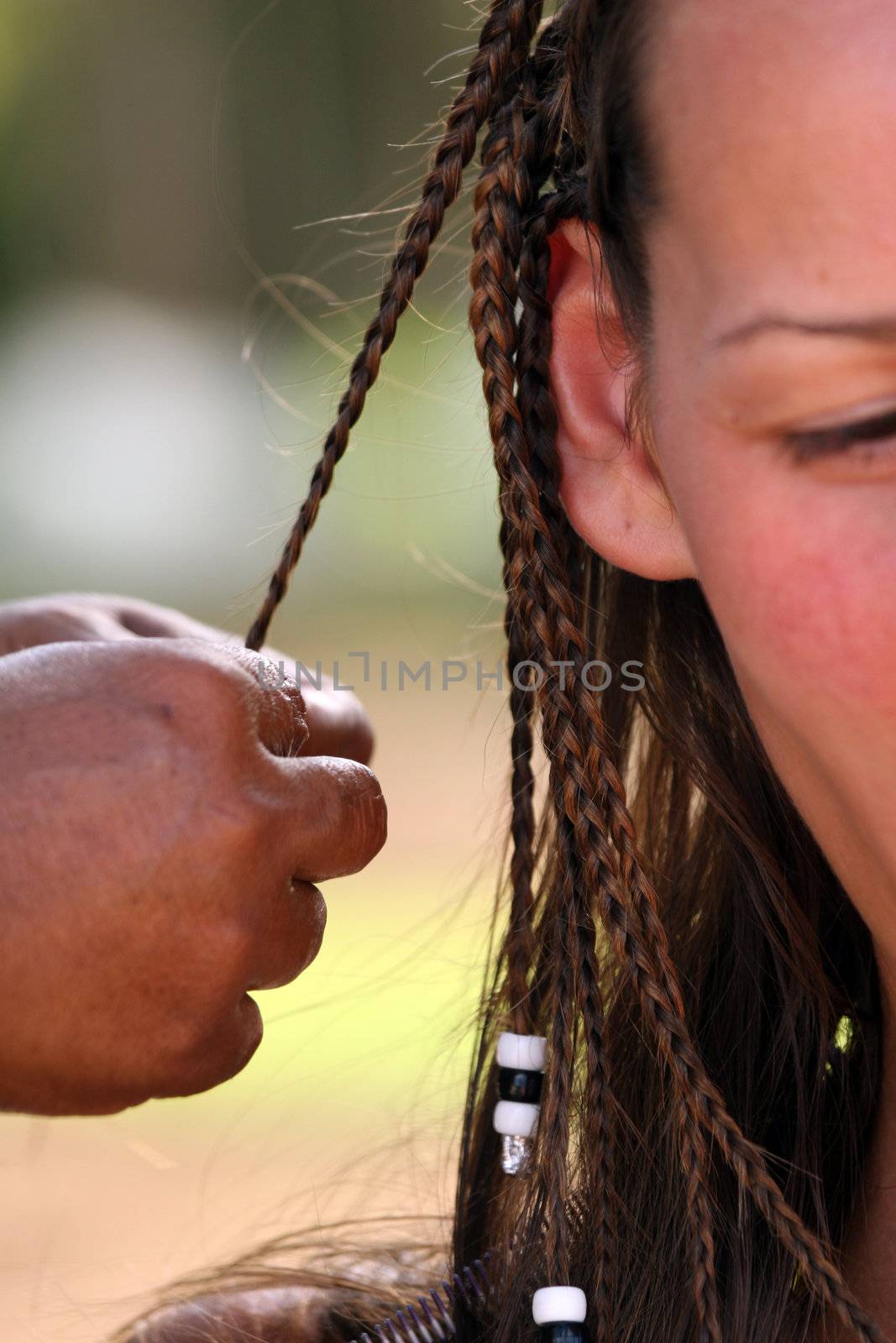 African woman making european woman braids