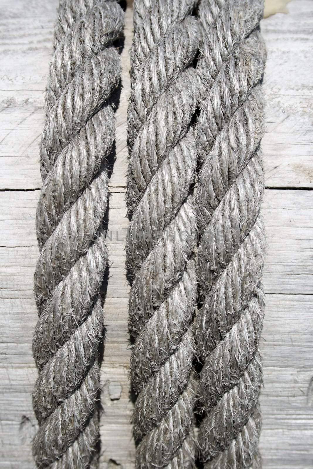 Gray boat rope on wooden background.