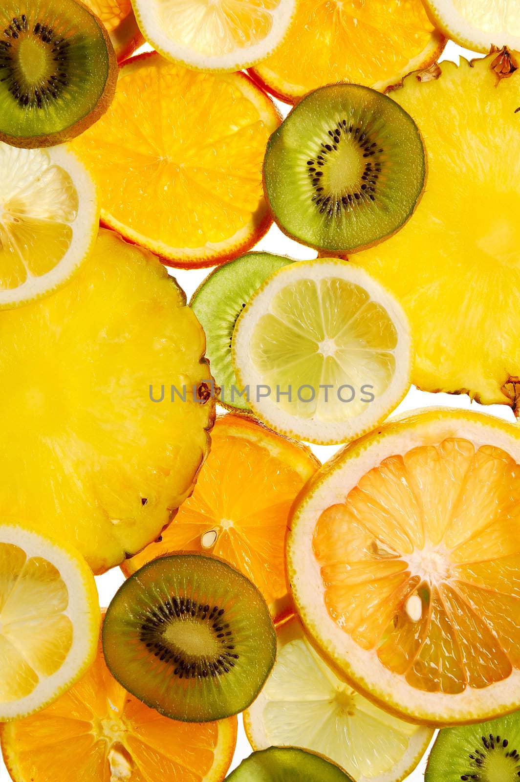 Sliced grapefruit lemon kiwi and pineapple on a light table