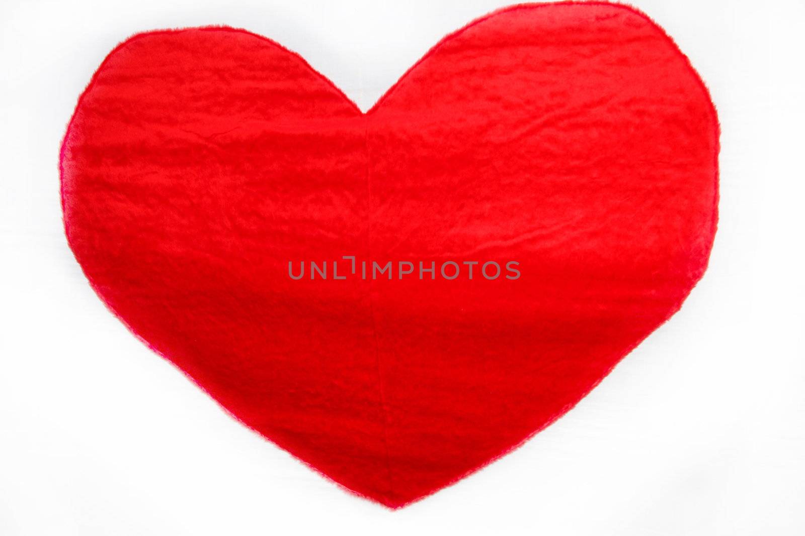 Red heart made of cloth against a white background