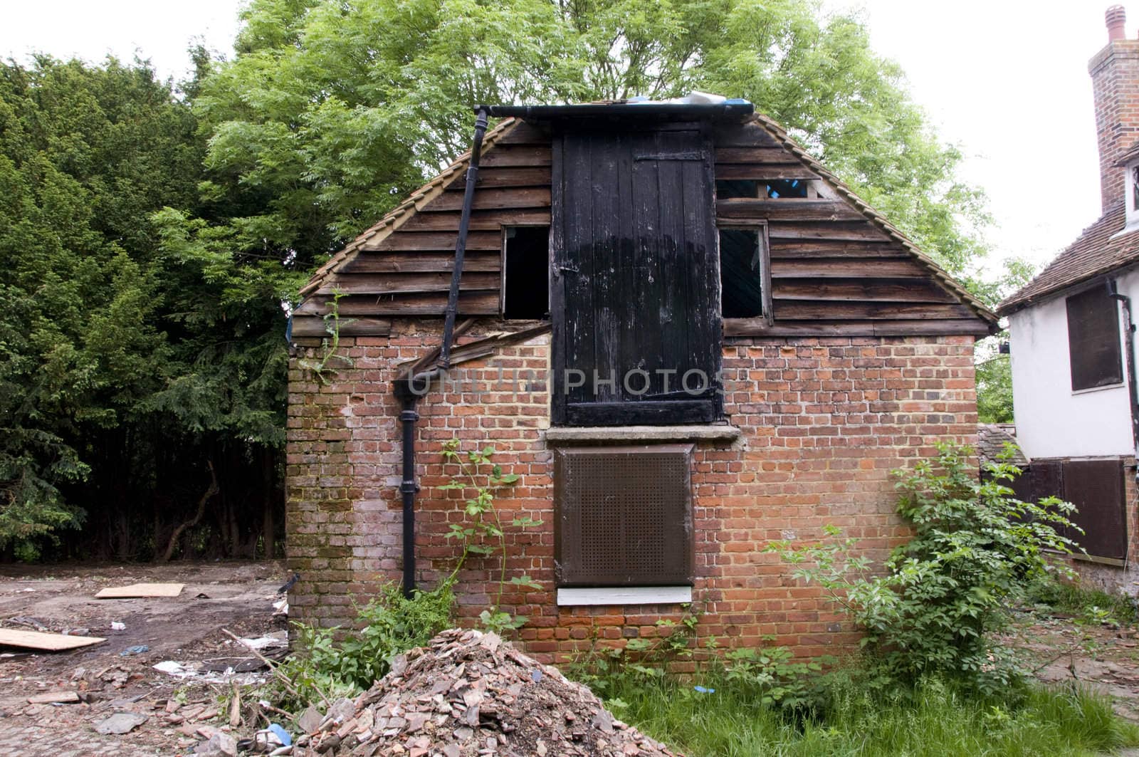 A run down old barn,with trees in the background