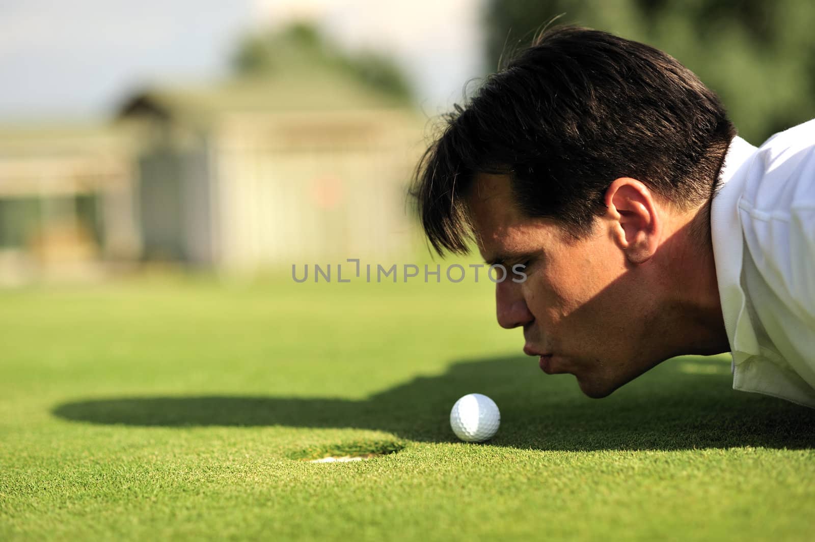 Golf man blowing on the ball