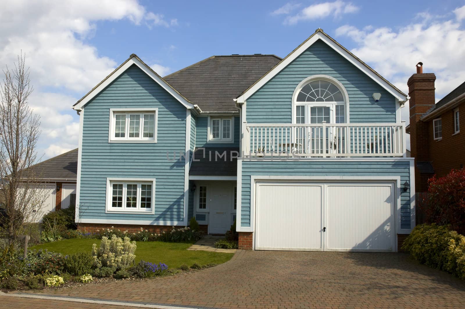 A blue wooden clad house with a cloudy sky