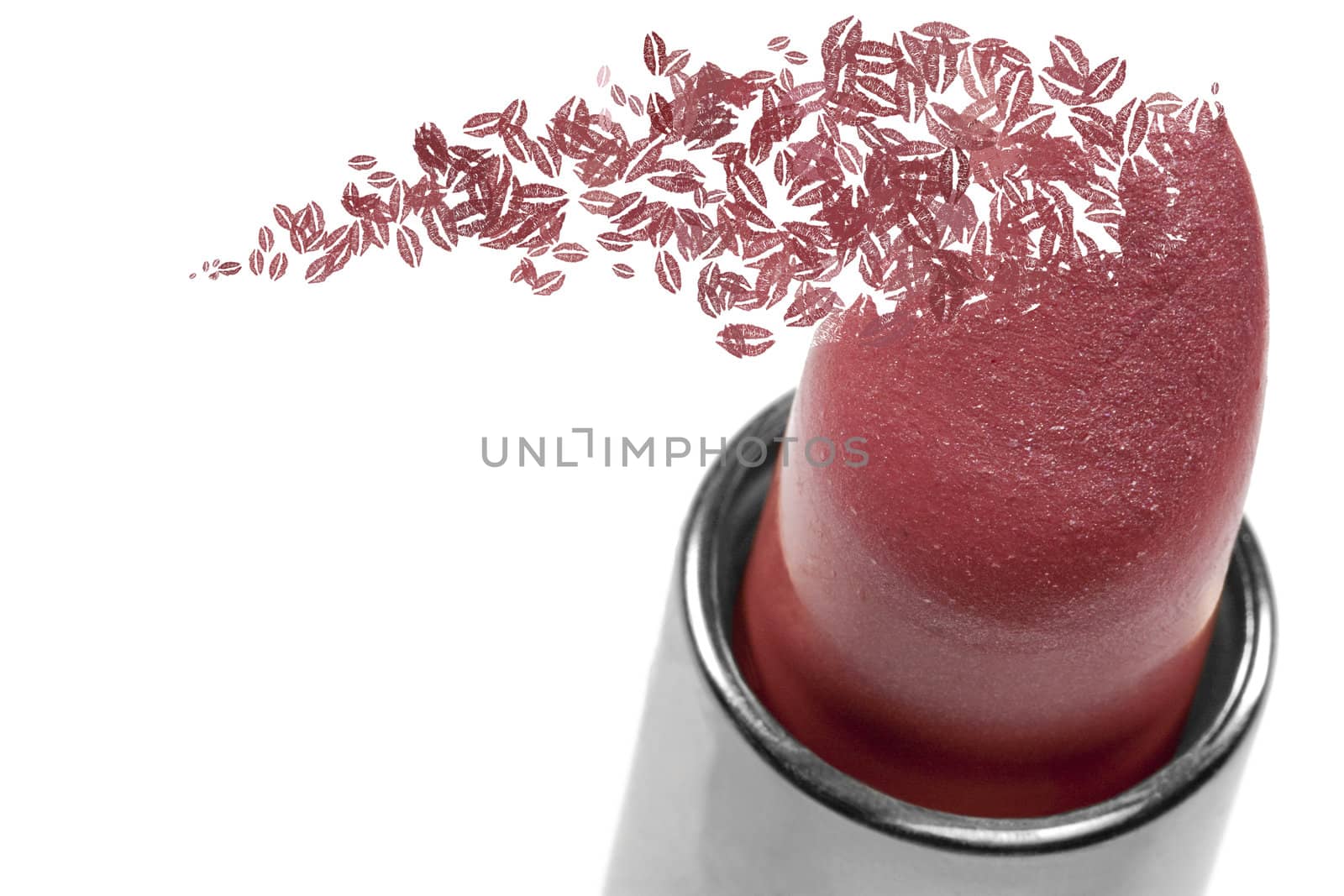 Close-up, shallow focus, tube of lipstick with lips scattering away in the wind.