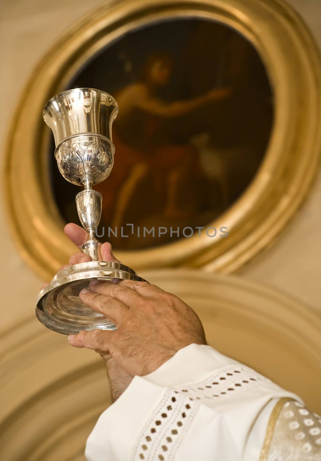 Priest's hands during Mass raising the chalice