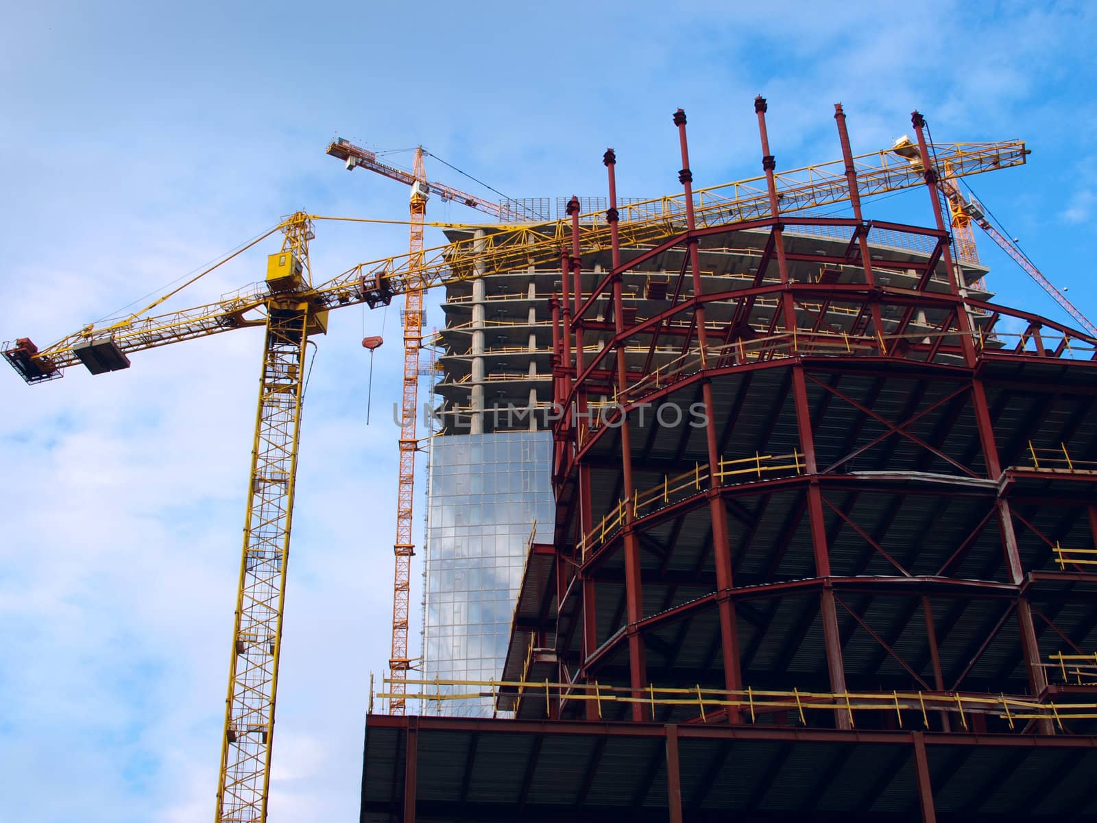 Two cranes and skyscraper building under construction