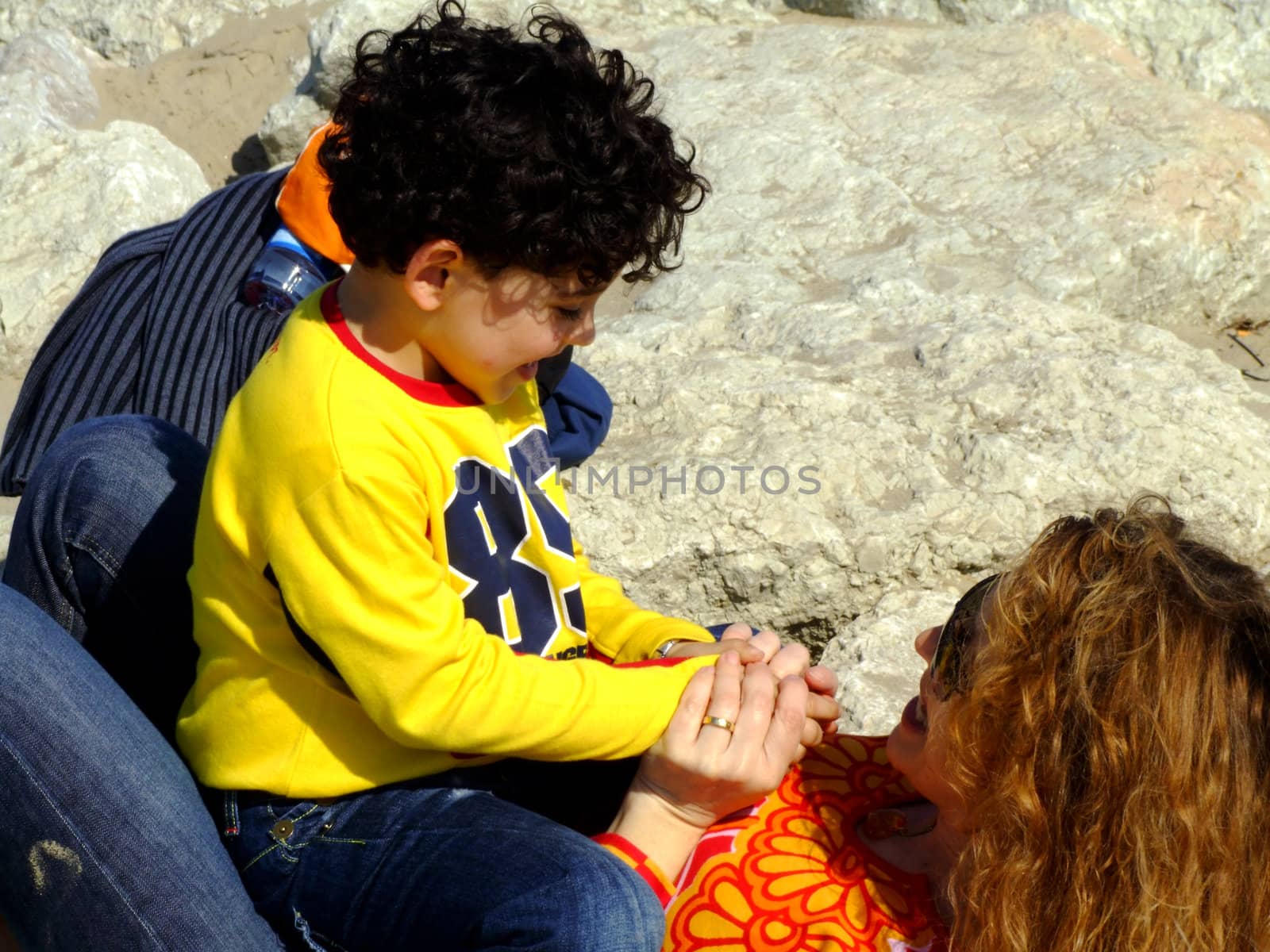 Mother and child playing on the rocks at the seaside