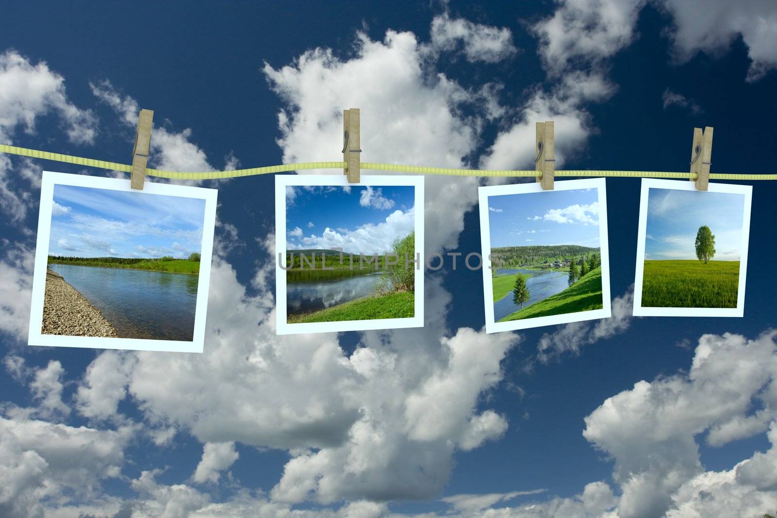 Landscape photographs hanging on a clothesline against a cloudscape