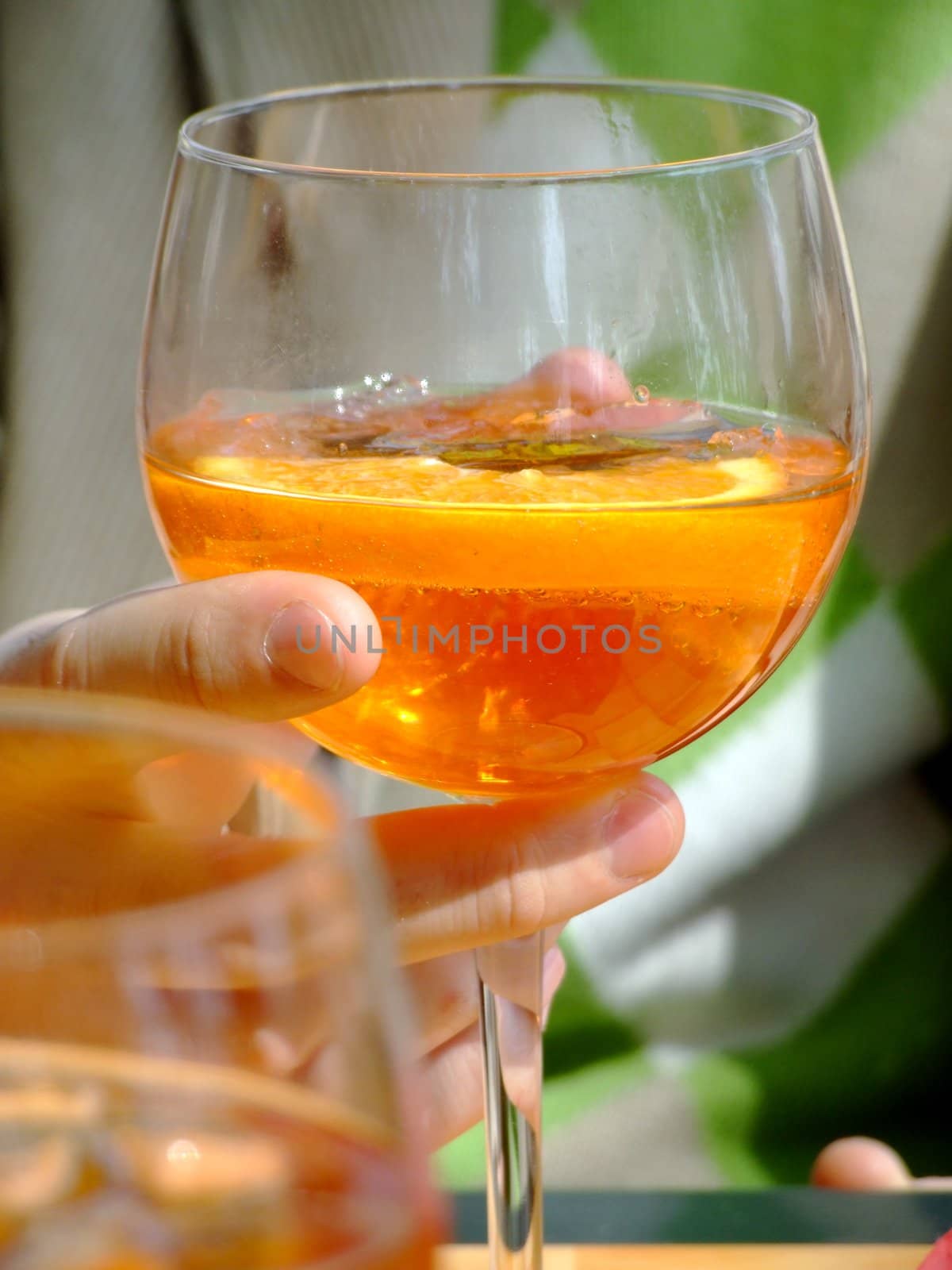 Hand holding a long drink glass during happy hour